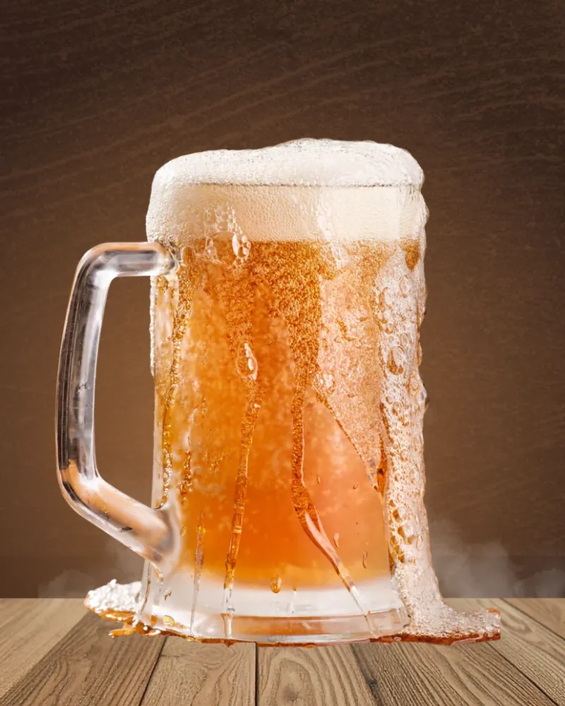 Caneca de chopp gelado com espuma transbordando