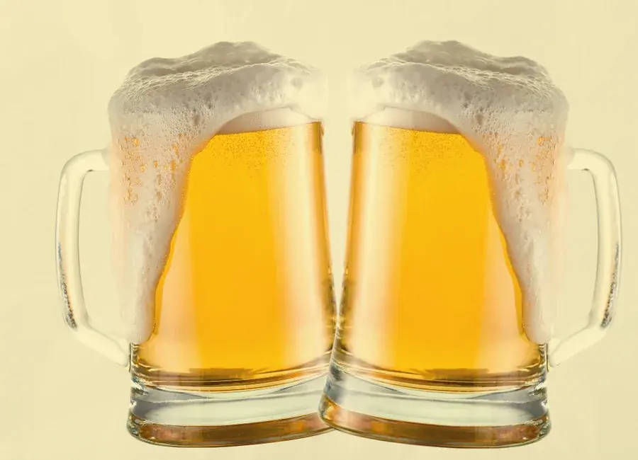 Duas canecas de chopp com espuma em brinde